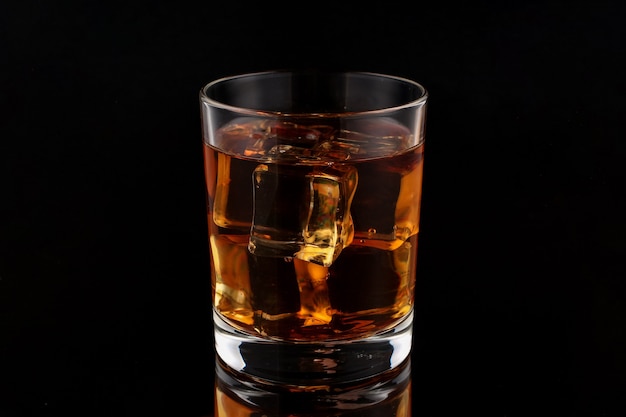 Whisky con hielo en un oscuro