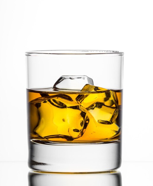 Whisky con hielo en un vaso de fondo blanco