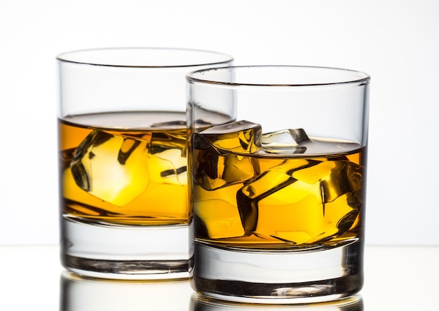Whisky con hielo en un vaso de fondo blanco