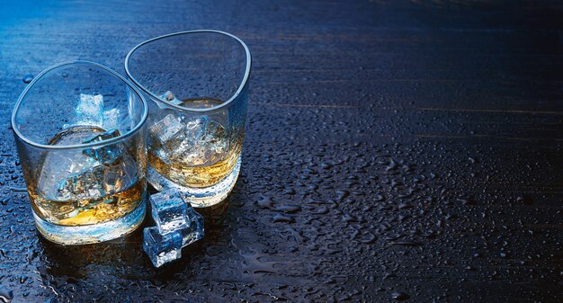 Foto whisky con hielo en vasos modernos