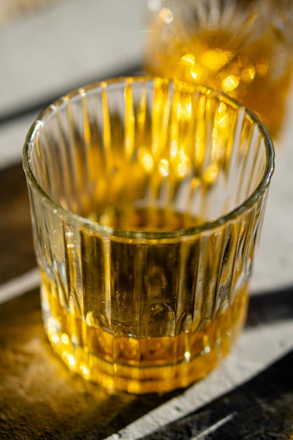 Whisky in Gläsern auf dem Tisch in hellem Sonnenlicht gelbes Getränk