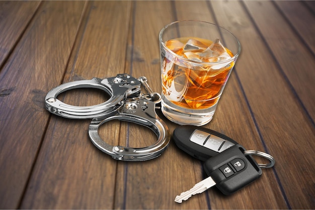 Whisky con llaves de auto y esposas aisladas