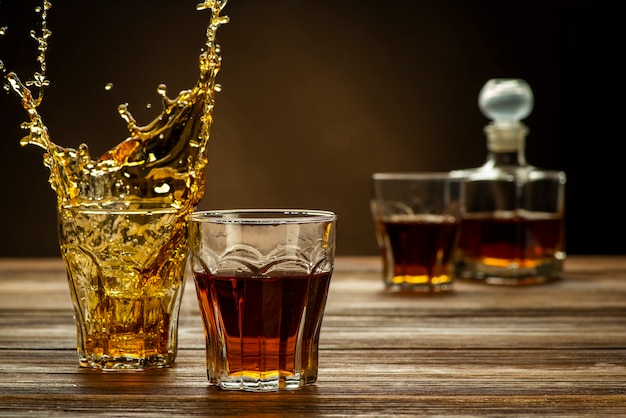 Whisky en la mesa con un chorrito en el vaso, bebidas alcohólicas fuertes