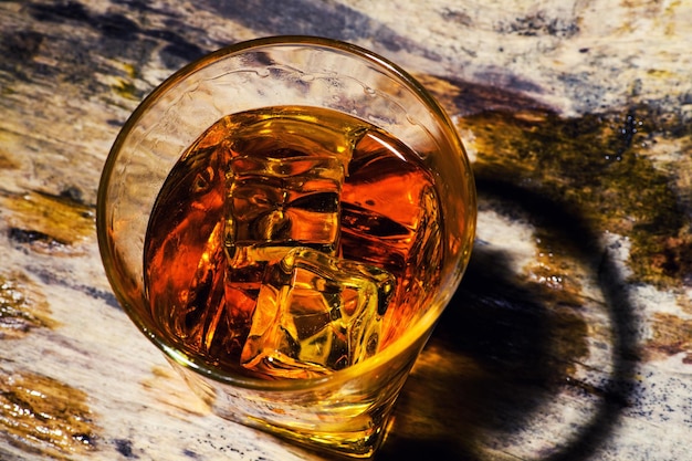 Foto whisky mit eiswürfeln auf hölzernem hintergrund