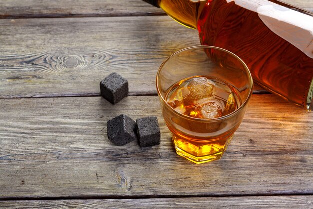 Whisky y piedras de whisky en una mesa de madera