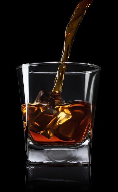 whisky vertiendo en un vaso con cubos de hielo sobre un fondo negro