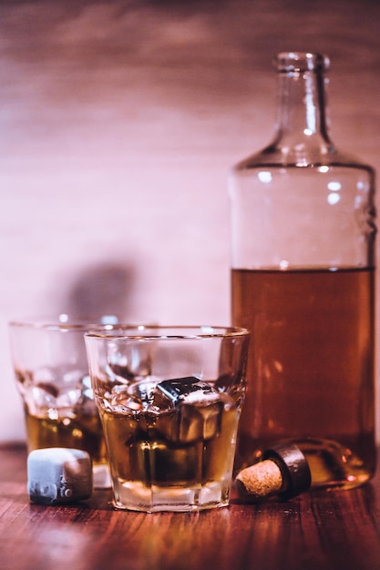 Whiskygläser auf rustikalem Holzhintergrund Alkoholgetränk Whiskey oder Bourbon mit Eiswürfeln