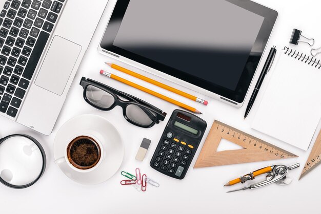 White Office Desk Laptop Telefon Tasse Kaffee Gläser Stift Bleistift Auf einem weißen Hintergrund Ansicht von oben Freier Platz für Text