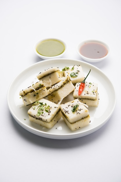 White Sandwich Dhokla é um petisco saboroso indiano feito de farinha de grão de bico ou farinha de arroz, originado em Gujarat. Servido com chutney de verde e tamarindo. foco seletivo