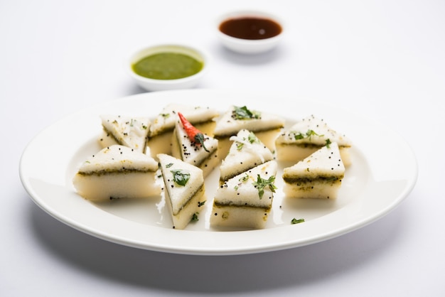 White Sandwich Dhokla é um petisco saboroso indiano feito de farinha de grão de bico ou farinha de arroz, originado em Gujarat. Servido com chutney de verde e tamarindo. foco seletivo