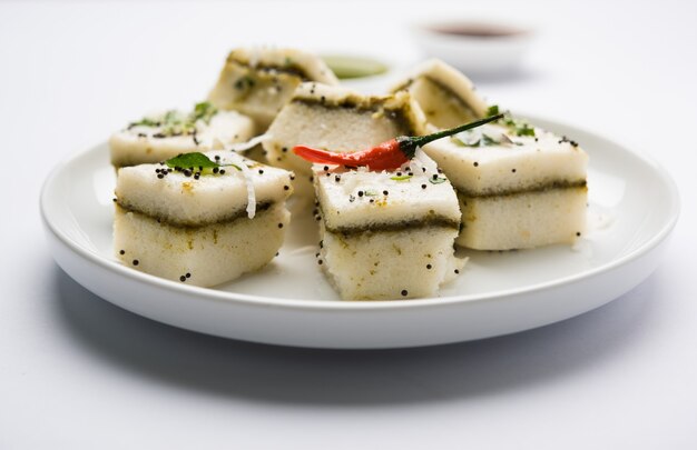 White Sandwich Dhokla ist ein indischer herzhafter Snack aus Kichererbsenmehl oder Reismehl, Ursprung in Gujarat. Serviert mit grünem und Tamarinden-Chutney. selektiver Fokus