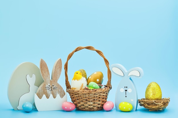 Whiteeggs en el nido y pollitos amarillos sobre un fondo azul Una tarjeta de Pascua con una copia del lugar para el texto