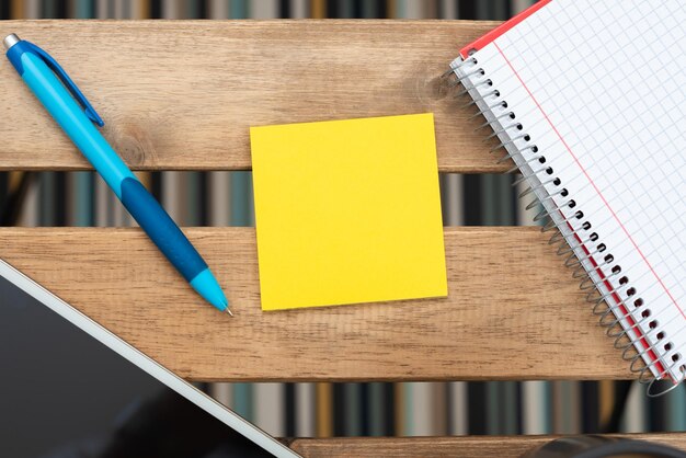 Wichtige Nachricht auf Haftnotiz mit Bildschirm des Stifttelefons und Notizbuch auf dem Tisch Wichtige Informationen auf dem Blatt Papier mit Tablet und Kugelschreiber