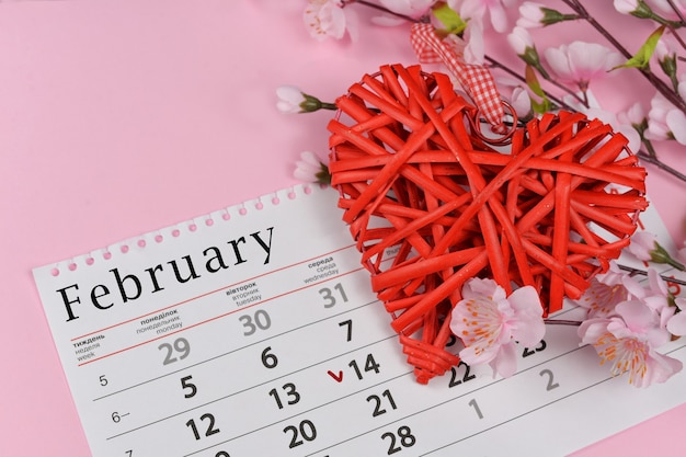 Wicker rotes Herz mit rosa Blumen mit einem Kalender