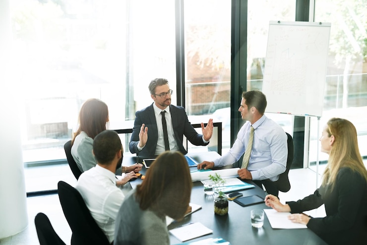 Foto wie die profis die tagesordnung der besprechung durcharbeiten aufnahme eines teams von führungskräften bei einer formellen besprechung in einem sitzungssaal