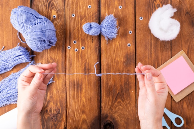 Wie man einen niedlichen Fadenvogel zur Dekoration herstellt. Kunstprojekt für Kinder. DIY-Konzept. Die Zeiger bestehen aus blauen Fäden einer blauen Taube. Schritt-für-Schritt-Fotoanleitung.