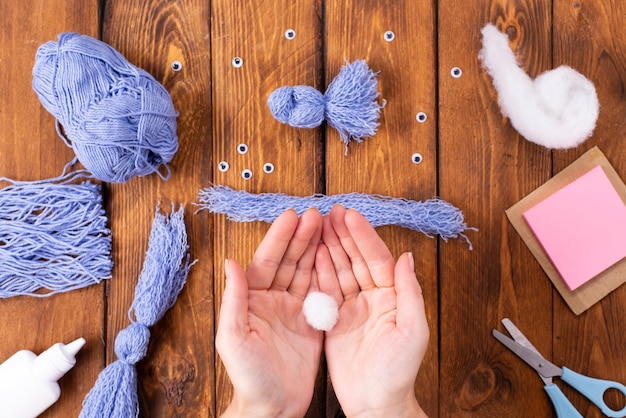 Wie man einen niedlichen Fadenvogel zur Dekoration herstellt. Kunstprojekt für Kinder. DIY-Konzept. Die Zeiger bestehen aus blauen Fäden einer blauen Taube. Schritt-für-Schritt-Fotoanleitung.