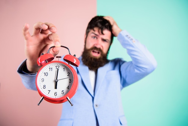 Wie viel Zeit bis zum Stichtag verbleibt Zeit zu arbeiten Mann bärtiger stressiger Geschäftsmann hält Uhr Stresskonzept Hipster stressiger Arbeitsplan Geschäftsmann hat Zeitmangel Zeitmanagement-Fähigkeiten