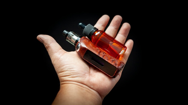 Wiederaufbaubarer Tankzerstäuber mit hochwertigen, stabilisierten Redwood-Maser-regulierten Box-Mods und E-Liquid-Flasche in der Hand