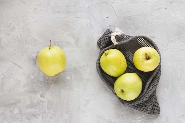 Wiederverwendbare Einkaufsnetztasche auf grau mit Apfelhintergrund Null Abfall kein Plastik