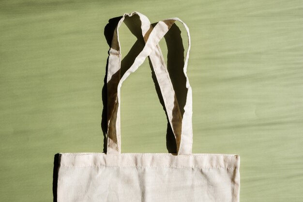 Wiederverwendbare Einkaufstasche aus Baumwolle auf grünem und beigem Hintergrund. Zero-Waste-Konzept. Kein Plastik.