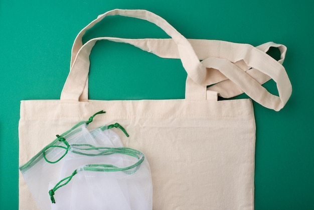 Wiederverwendbare Einkaufstaschen auf grünem Hintergrund Null-Abfall-Konzept