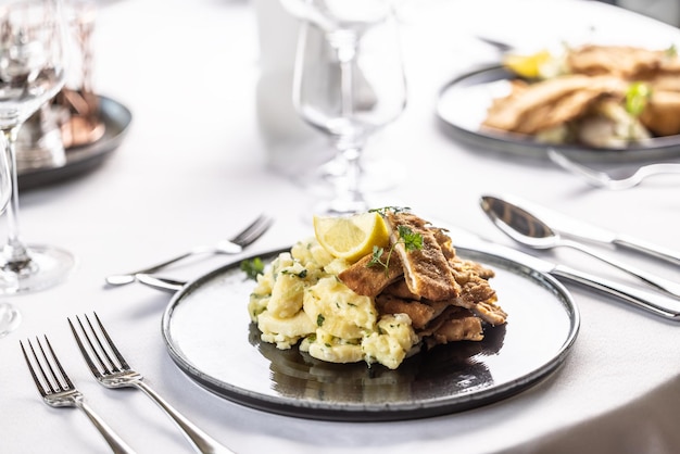 Foto wiener schnitzel in stücke schneiden und auf einem kartoffelsalatstapel servieren