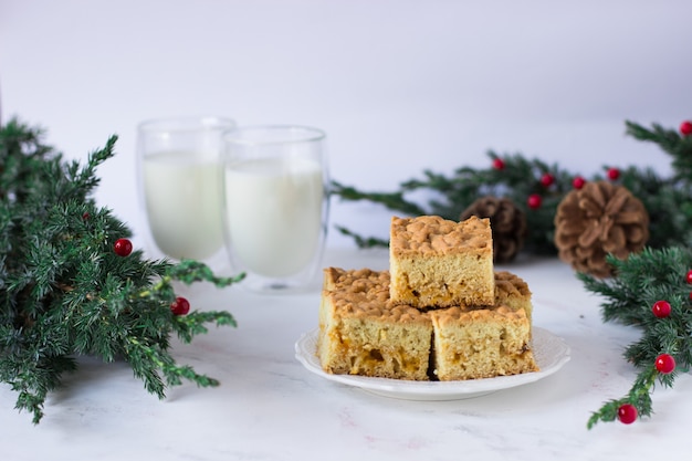 Wiener Torte auf einem weißen Tisch gegen die Gläser mit Milch- und Fichtenzweigen