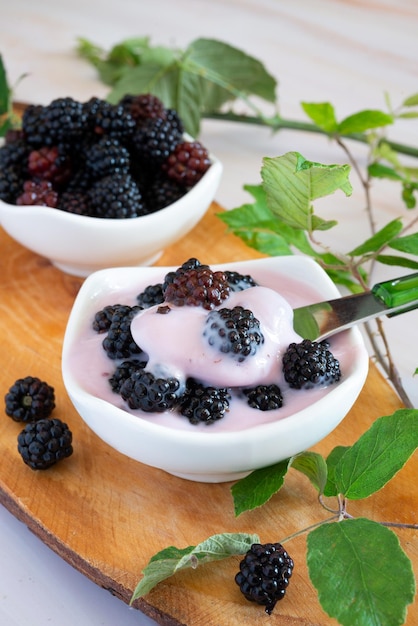 Foto wildbeeren natürlich auf einem holzschneidebrett mit cremigem joghurt