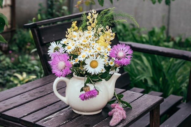 Wildblumen in einer alten kleinen Dorfteekanne. Getönt