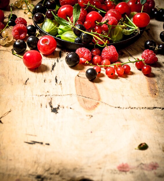 Wilde Beeren in der alten Platte auf Holztisch