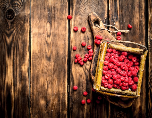 Wilde Himbeeren im Korb. Auf einem Holztisch.