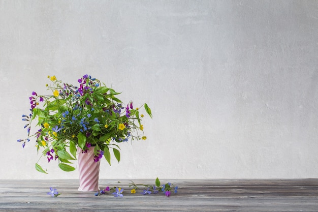 Wilde Sommerblumen in der rosa Keramikvase auf weißem Hintergrund