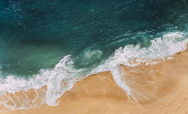 Foto wilder strand mit einem schönen klaren ozean ozean aus der vogelperspektive draufsicht auf den tropischen strand paradiesinsel einsamer sandstrand mit wunderschönen wellen strände von indonesien kopieren sie platz