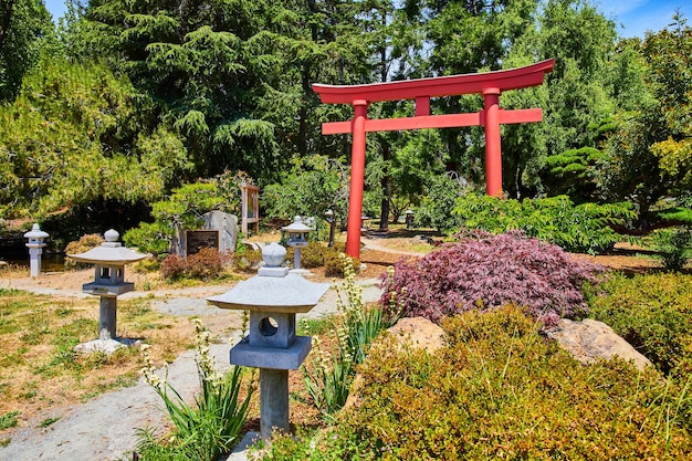 Foto willkommen torii gate im japanischen garten mit steinernen laternen, die den weg an einem sonnigen tag säumen