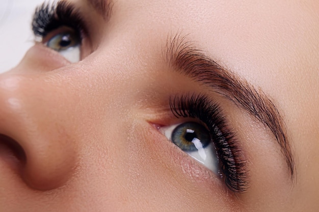 Wimpernverlängerungsverfahren frau auge mit langen blauen wimpern ombre-effekt nahaufnahme selektiver fokus