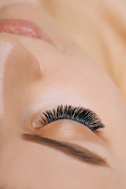 Wimpernverlängerungsverfahren Frauenauge mit langen Wimpern Nahaufnahme selektiver Fokus