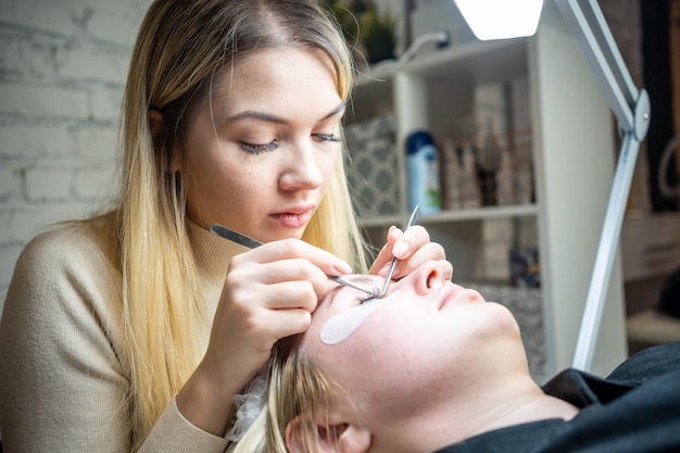 Wimpernverlängerungsverfahren im Schönheitssalon Wimpern Nahaufnahme Konzept Spa Wimpern