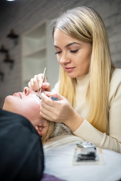 Wimpernverlängerungsverfahren im Schönheitssalon Wimpern Nahaufnahme Konzept Spa Wimpern