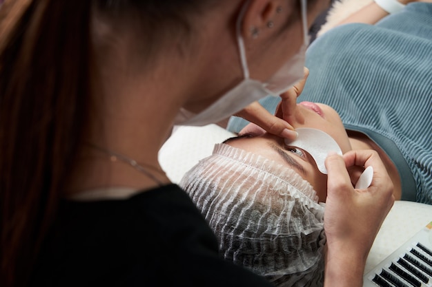 Wimpernverlängerungsverfahren Nahaufnahme schöne Frau mit langen Wimpern in einem Schönheitssalon