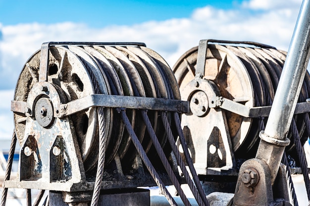 Winde aus Metall. Drahtseilschlinge oder Seilschlinge auf Krantrommeltrommel oder Windenrolle des Krans die Hebemaschine in der Schwerindustrie gegen den Himmel.