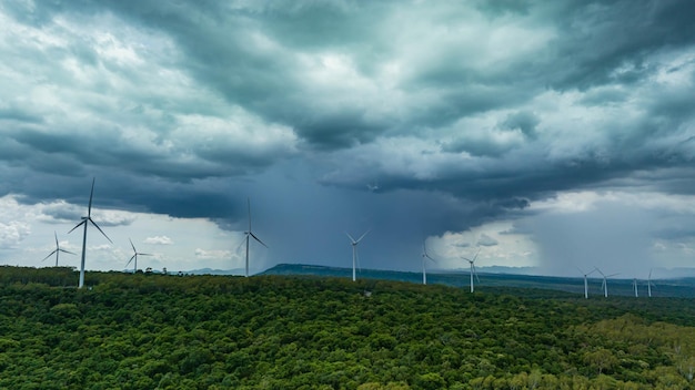 Windkraftanlage auf dem braunen Gras über dem Berg, der vom Sturm blau bewölkt ist