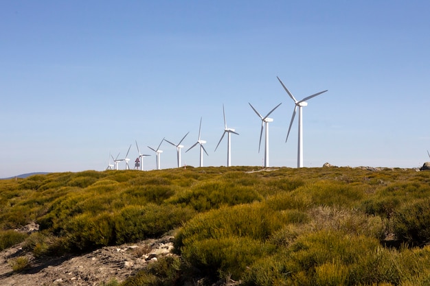 Windkraftanlagen auf einer bergigen Wasserscheide erzeugen Strom durch die Kraft des Windes