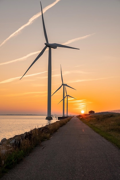 Windkraftanlagen bei Sonnenuntergang. Grüne Ökostrom-Energieerzeugung. Öko-Feld des Windparks. Grüne Energie für Offshore- und Onshore-Windmühlen auf See.