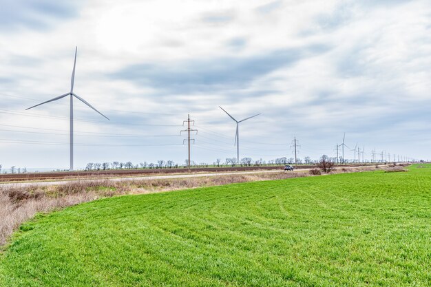 Windkraftanlagen, die Elektrizität auf einer grünen Wiese erzeugen