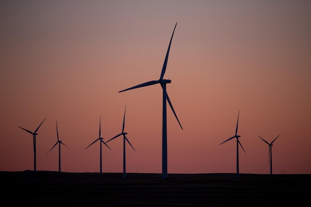 Windkraftanlagen in einem Feld bei Sonnenuntergang in einem ländlichen