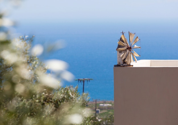 Windmühle in Miniatur auf der Brüstung einer Terrasse mit Meerblick