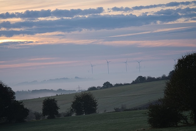 Windmühle in nebliger Landschaft Erneuerbare Energien für eine umweltbewusste Zukunft