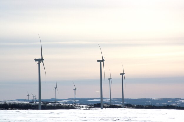 Windmühlengeneratoren Schneelandschaftskraftwerk elektrische Turbine saubere Energie und Ökoenergiekonzept