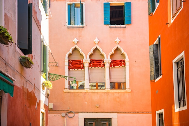 Windows en pared roja en casa antigua en Venecia.